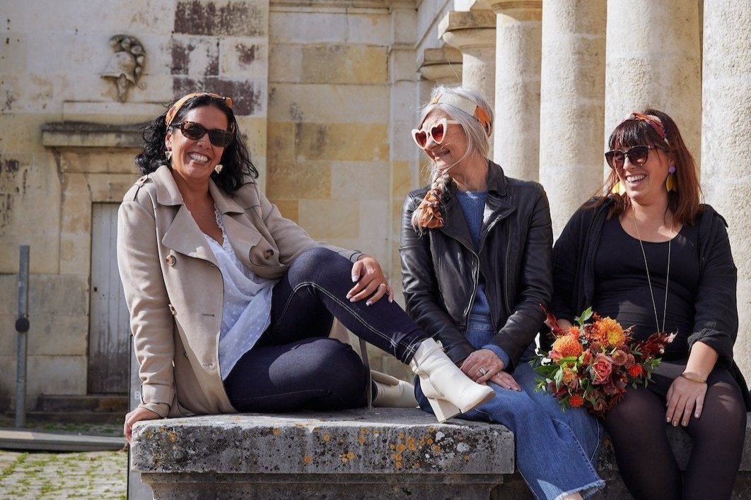 Photo de 3 modèles de femme qui sourit avec des bandeaux colorés noués dans les cheveux