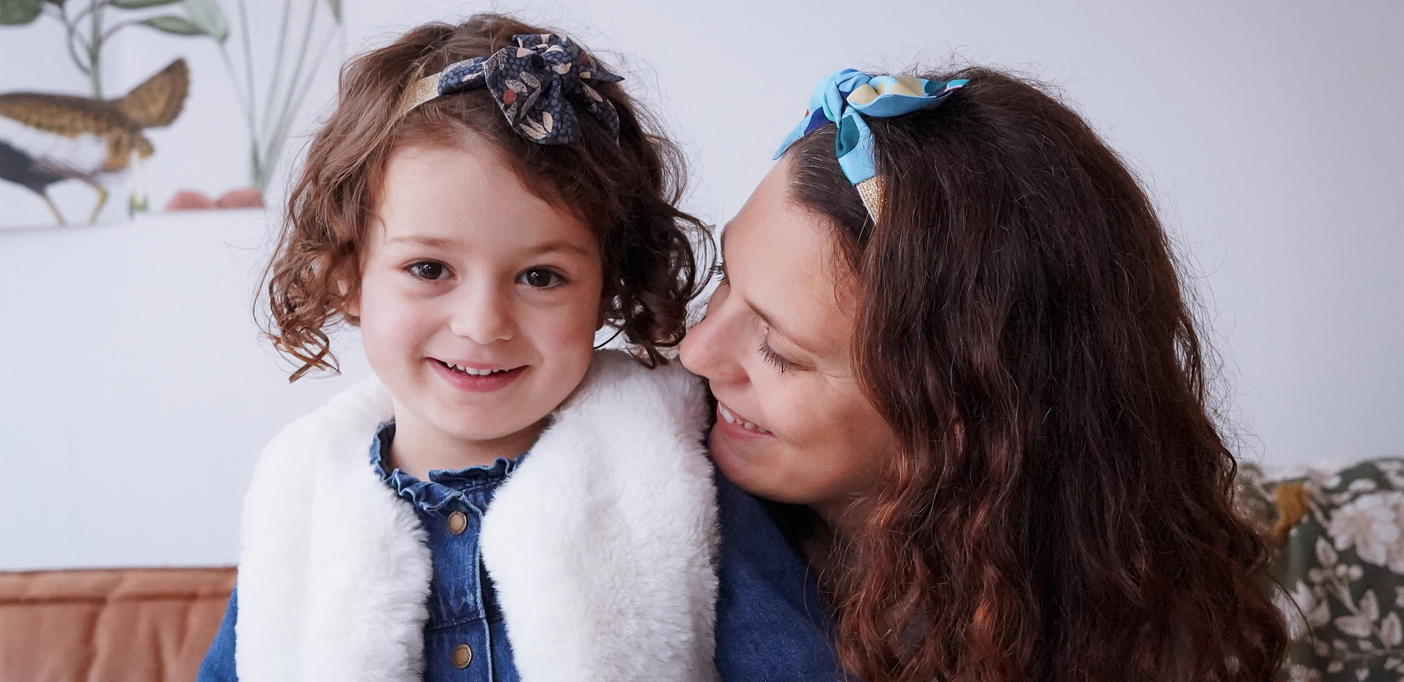 Mère et fille avec bandeau élastique coloré dans leurs cheveux bouclés châtain